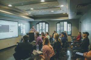 a group of people in a room with a projector screen