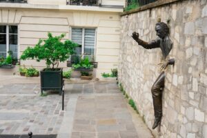 man trying to escape statue on wall