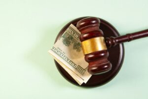 A gavel rests on a sound block with money