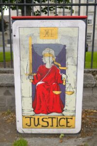A street box painted with justice tarot card